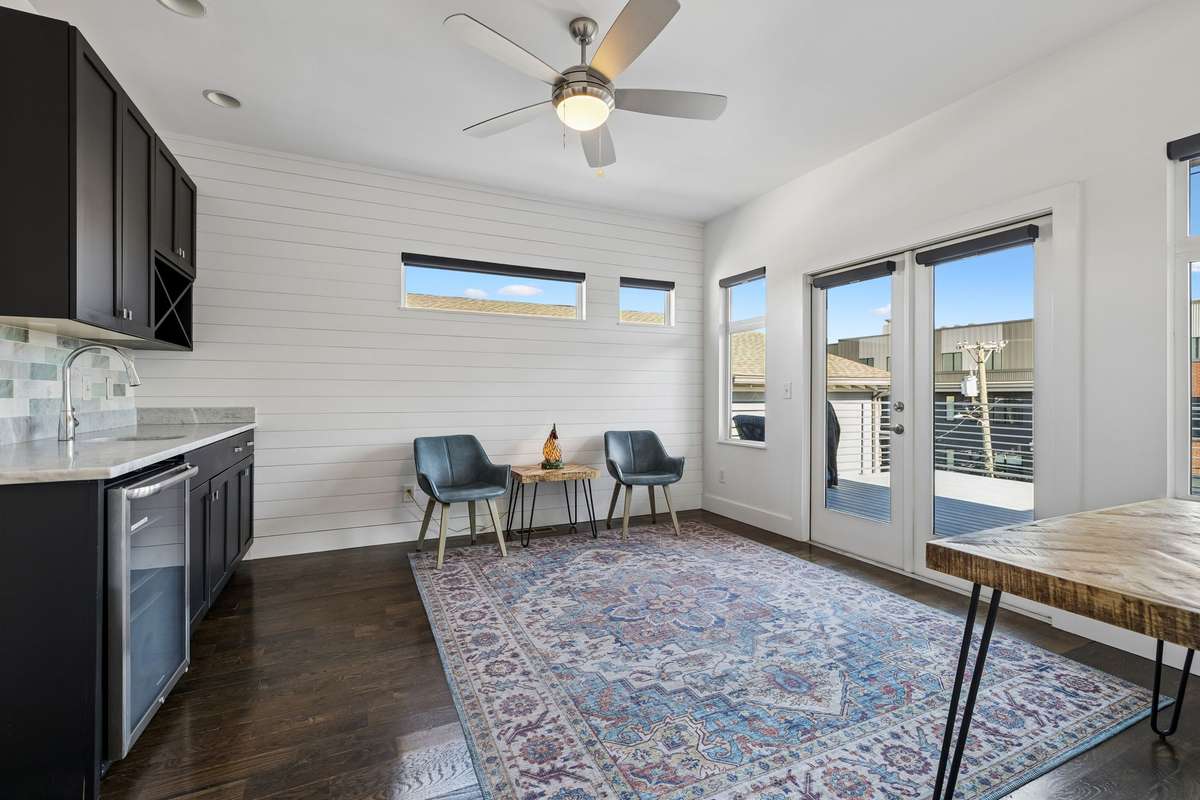 Third-floor rooftop deck level featuring an open flex space. Wet bar with sink, beverage refrigerator and storage!  Perfect for entertaining!