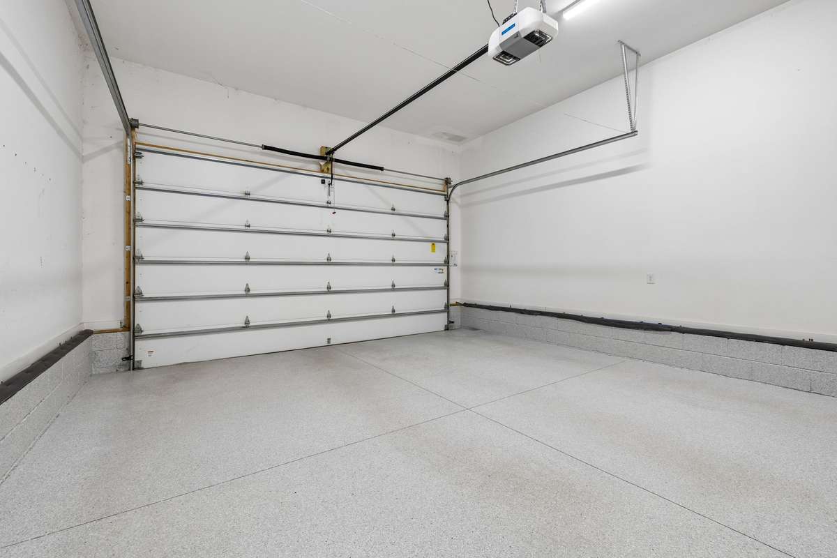 Attached two-car garage with epoxy flooring and ample storage space.