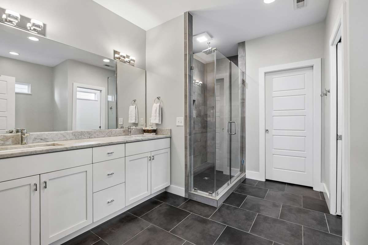 Spacious primary bath features: double vanity, a large walk-in glass shower and seperate soaking tub, a water closet, a walk-in closet, and modern fixtures throughout.