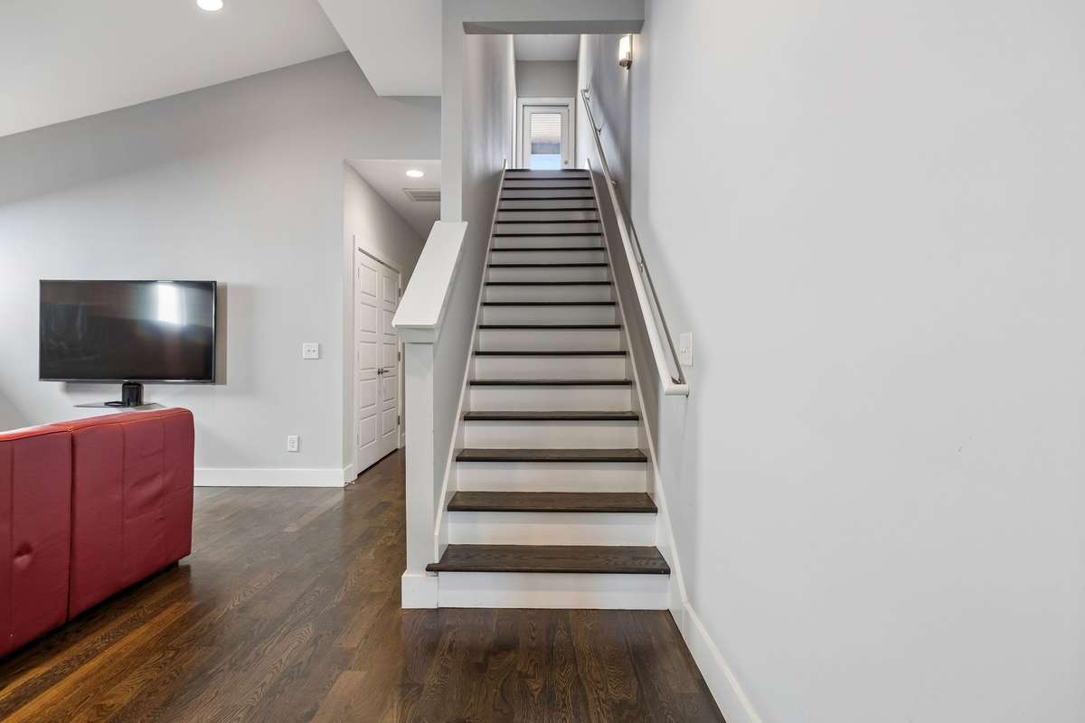 Walking up to the third floor which offers abundant natural light, large flex space with full wet bar, half bath, and rooftop deck!