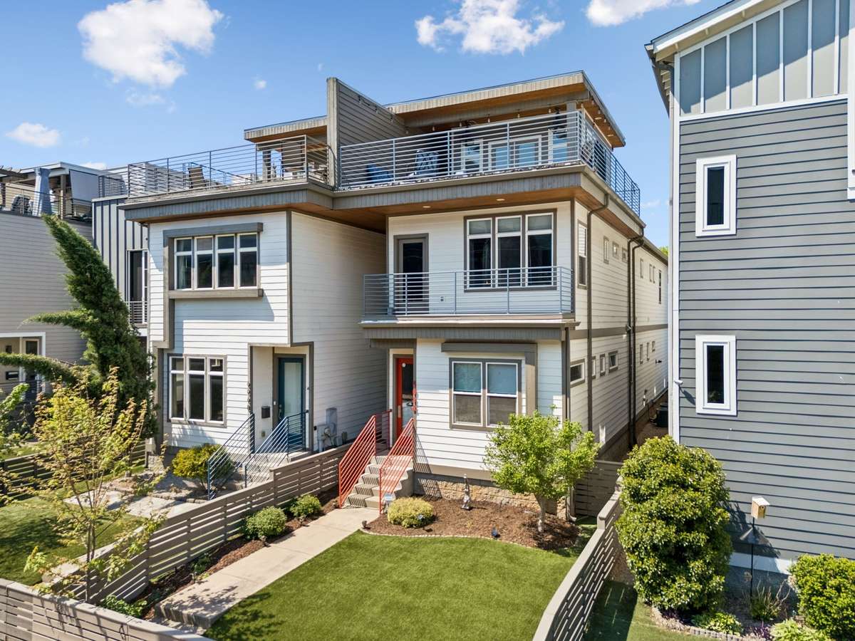 Fenced-in turf front yard for low-maintenance living, with a second-story balcony and a third-story rooftop deck!