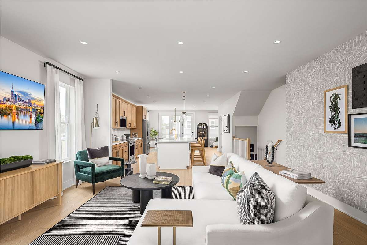 The living area blends effortlessly with adjacent spaces—such as the kitchen or dining area—creating a cohesive environment that encourages conversation and easy movement.*Photos are of a similar floorplan with differing finishes*