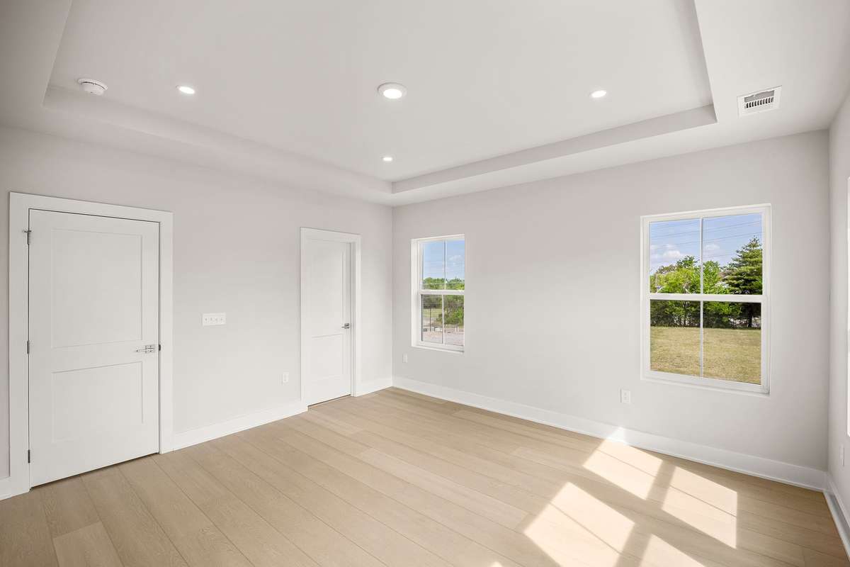 In the 3rd floor primary suite, you'll find dual walk-in closets, a tray ceiling & extra windows for natural light.
