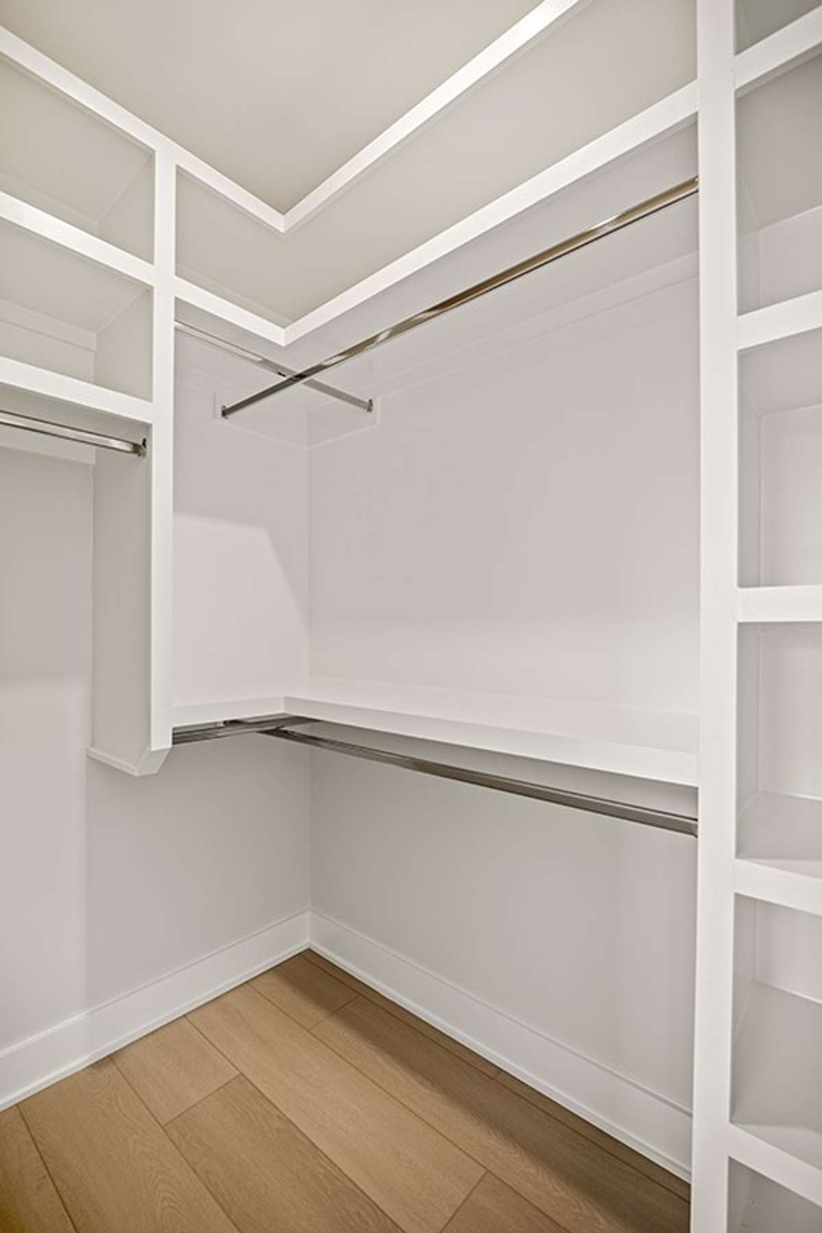 Each of the two walk-in closets in the primary suite feature custom wood shelving.