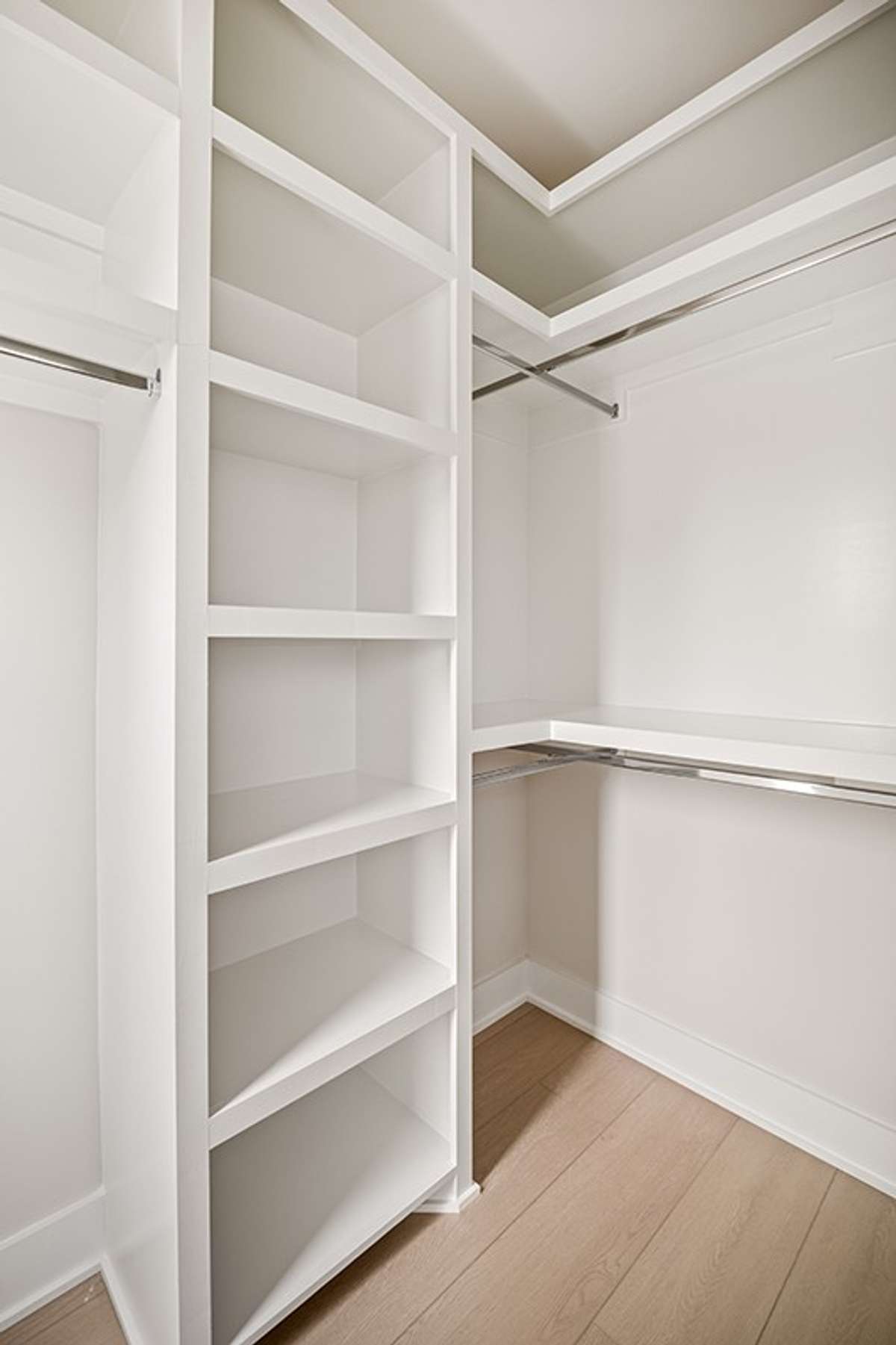 Each of the two walk-in closets in the primary suite feature custom wood shelving.