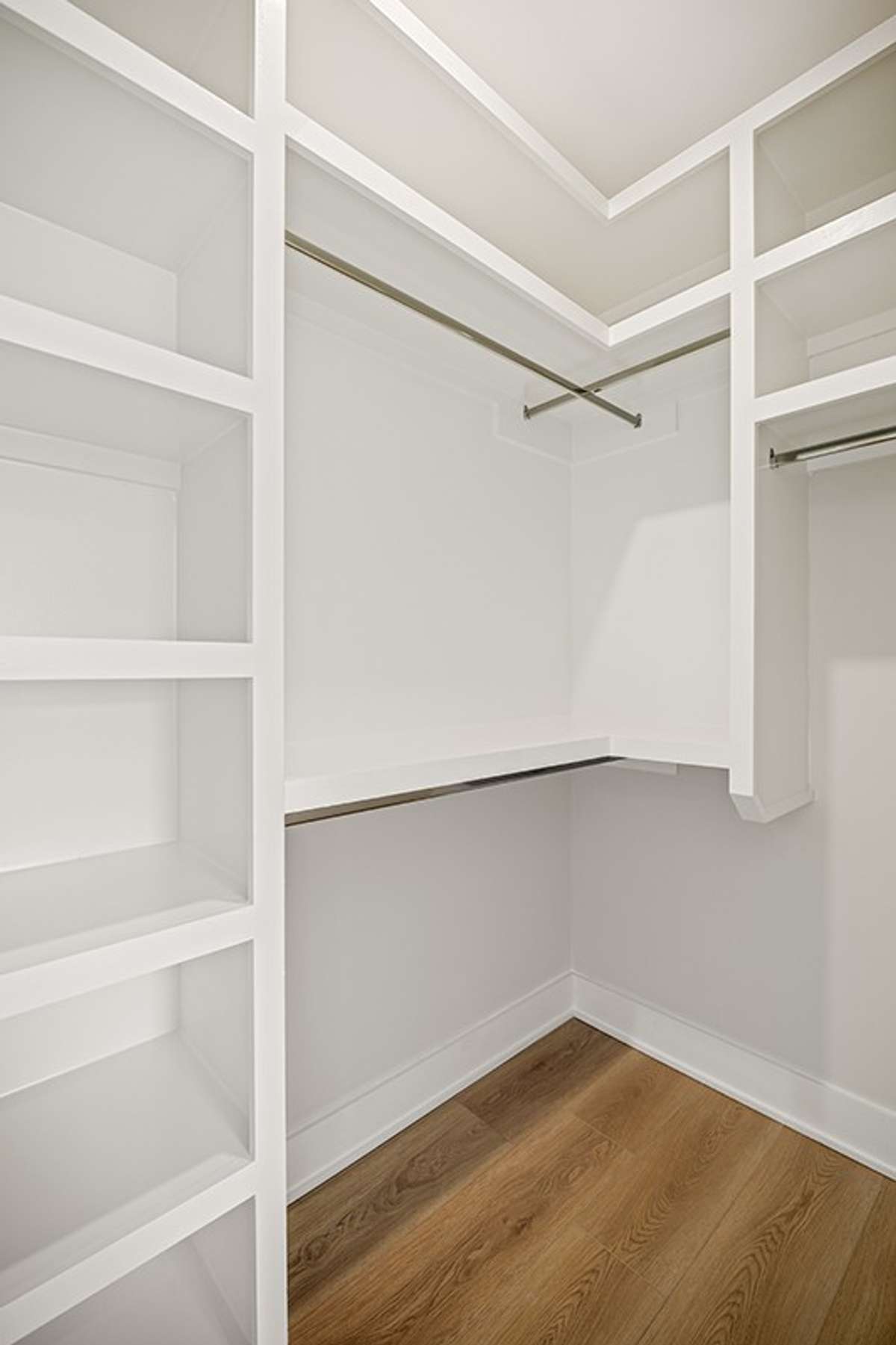 The primary suite's dual walk-in closets both feature custom wood shelving throughout.