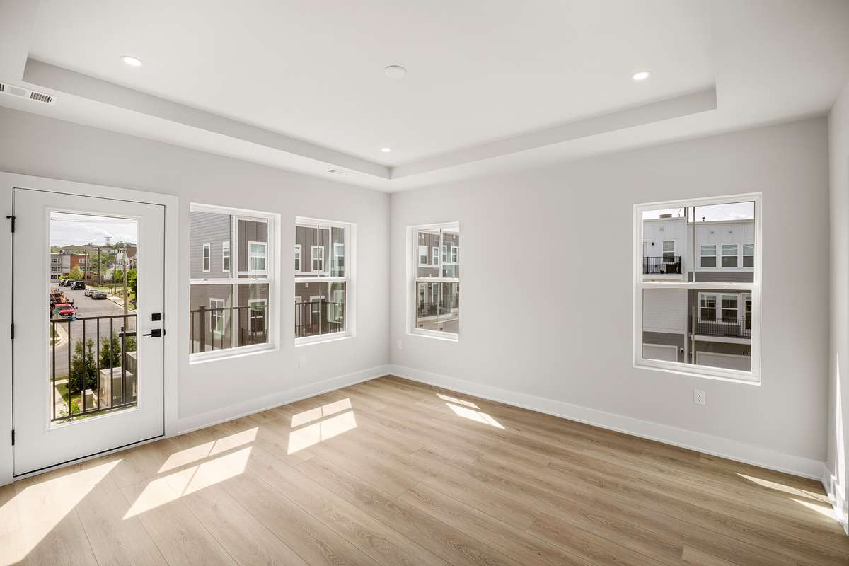 The 3rd floor primary suite features a tray ceiling, private balcony & tons of natural light.