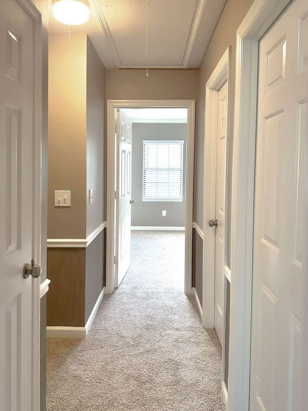Upstairs hallway featuring upgraded lighting, new carpet, and fresh paint.