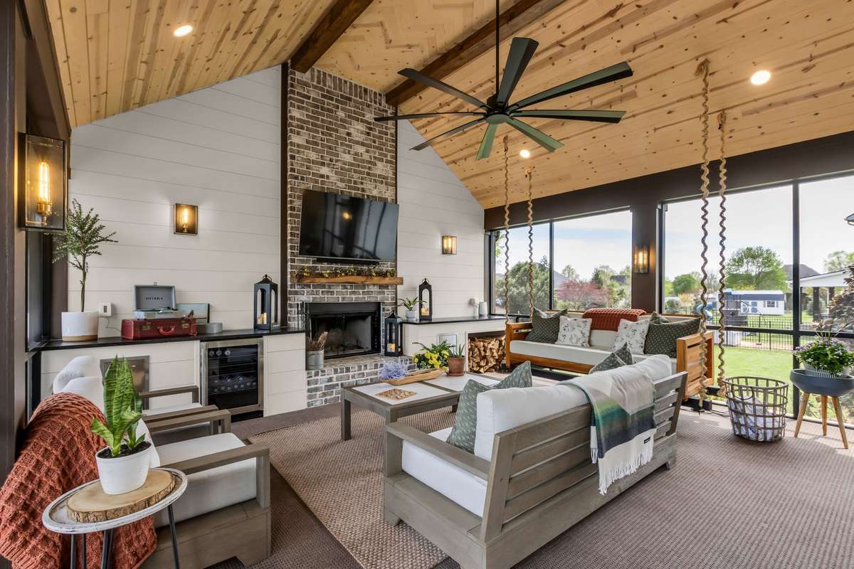 The cozy fireplace is flanked by quartz counters & cabinetry that houses the beverage cooler, pull out trash & nook for firewood storage. There is an electrical outlet in the ceiling.