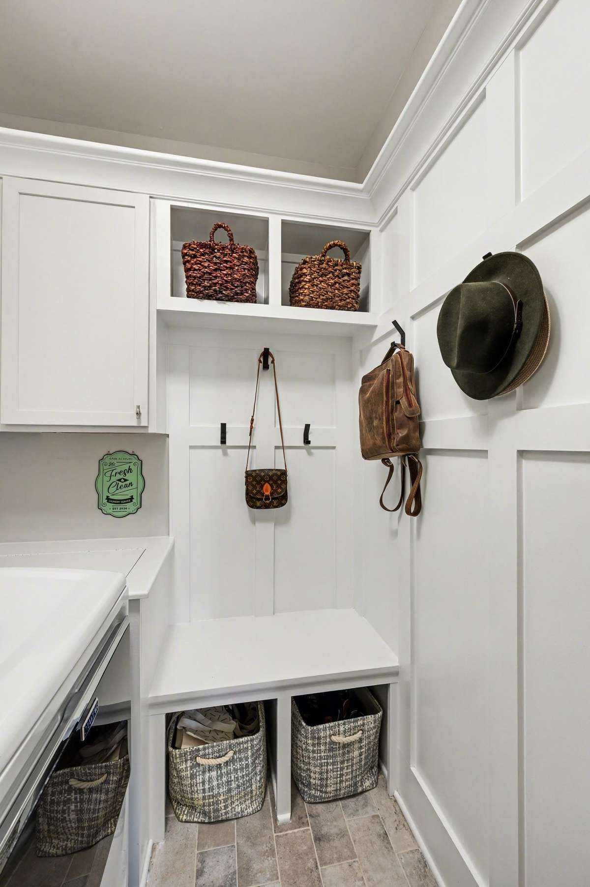 Drop zone with hooks and cubbies is adjacent to the washer & dryer.