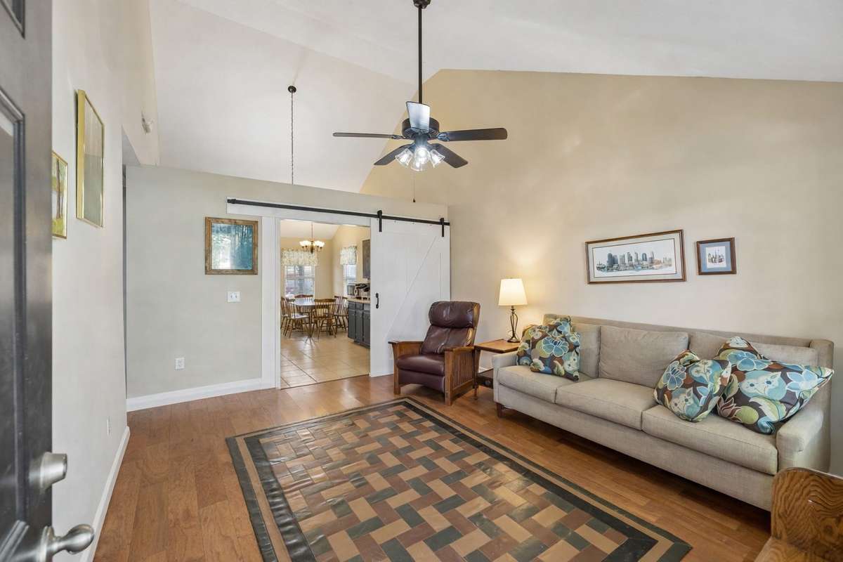 Large living room with vaulted ceilings, neutral color scheme & ceiling fan. 2739 Oxford Hall Ave. Murfreesboro, TN 37128
