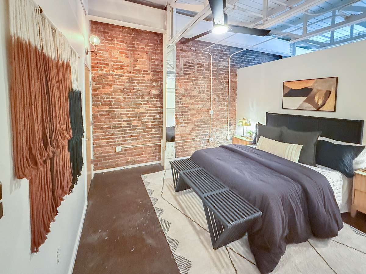 Exposed brick and updated period sconces adds warmth and authentic industrial character.