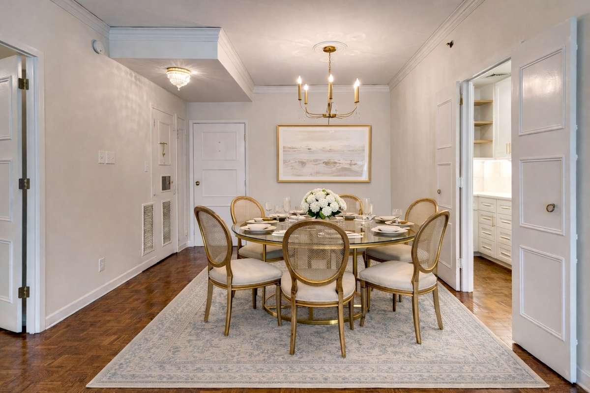 A stunning gold and acrylic chandelier sets the stage for this charming dining room.  Virtually staged.