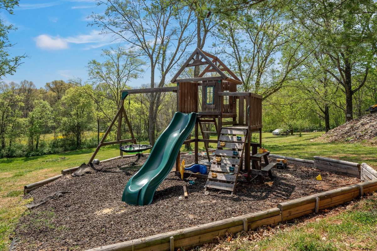 This amazing outdoor space with a wooded backyard and expansive lawn has a dedicated play area, ideal for outdoor living.