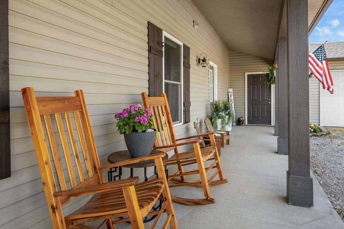 Relax on this welcoming covered front porch with charming shutters and a welcoming entry.