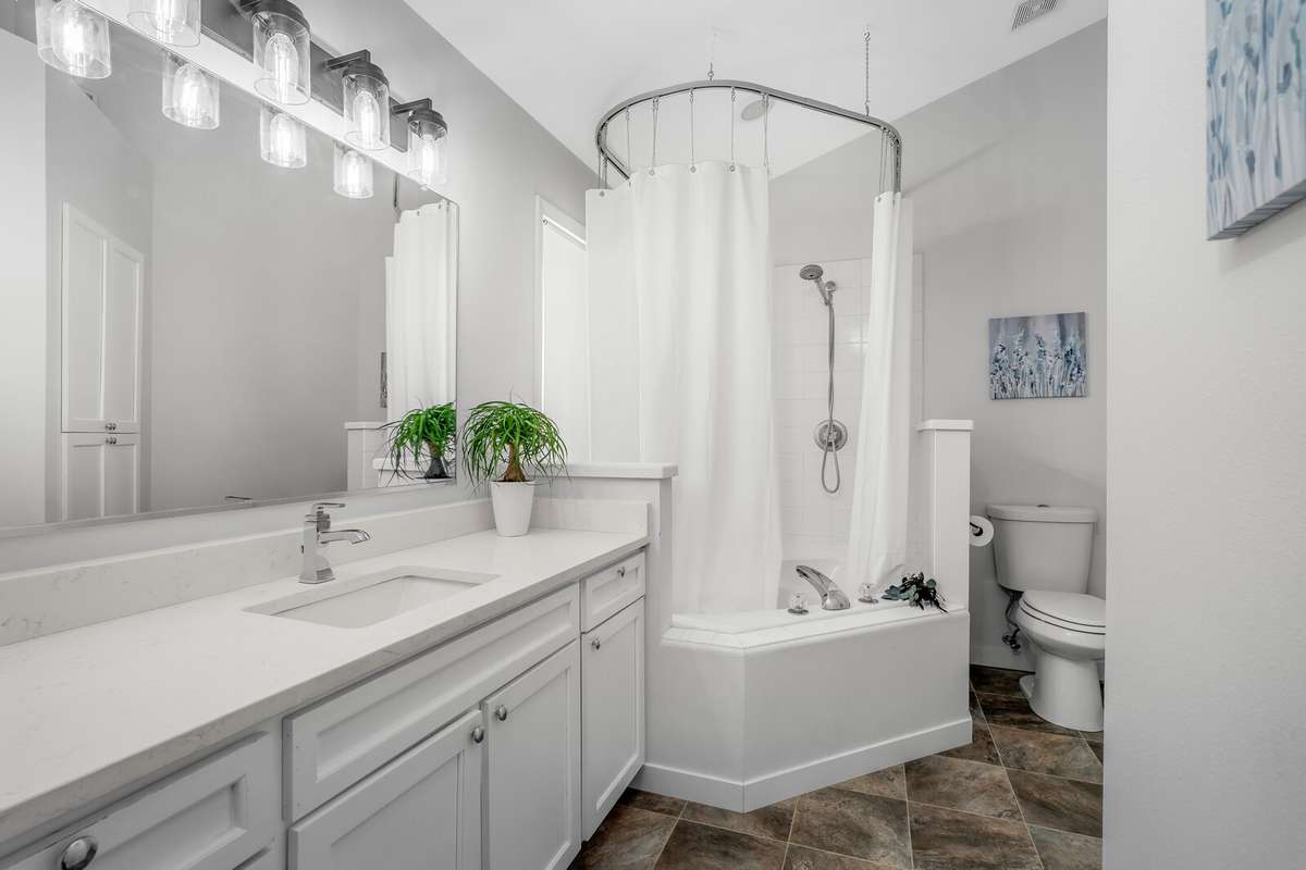 Primary bath attached to the master offers a large countertop/ cabinet space and a deep tub/ shower combo.