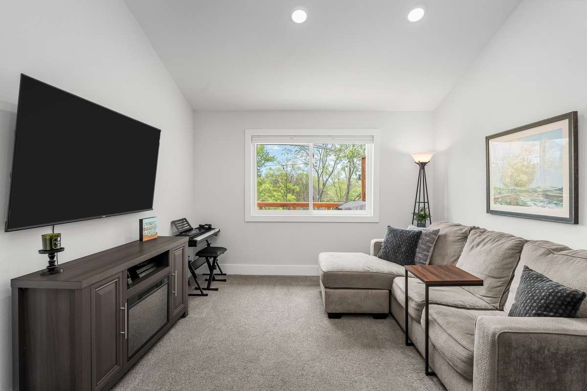 An additional view of the separate living space. The plush carpet adds a welcoming touch and all of the great lighting helps to make this room a versatile option for any of your daily needs.