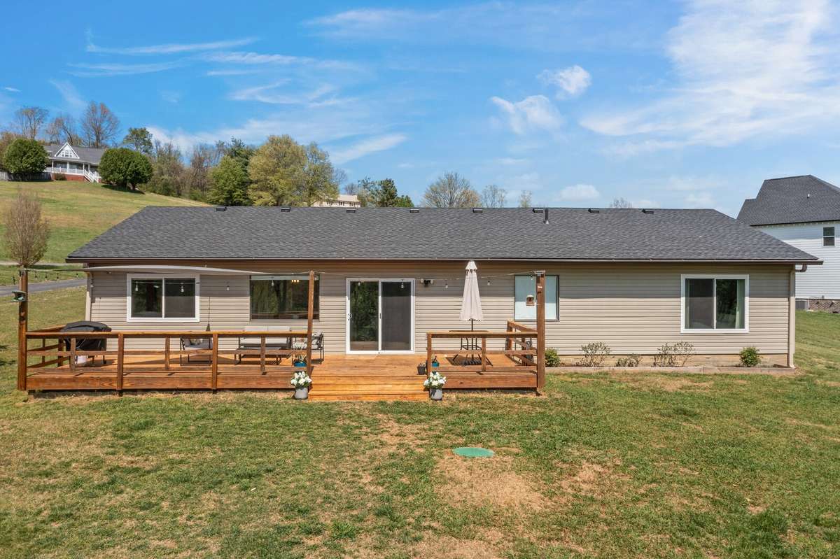 The back view of the home. Spacious backyard deck with wide steps, and a sliding door for easy indoor-outdoor living is fantastic.