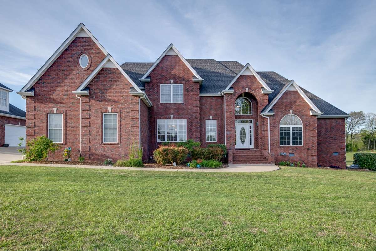 Beautiful brick home with 3 car attached garage and 3 car detached garage sits on 1 acre