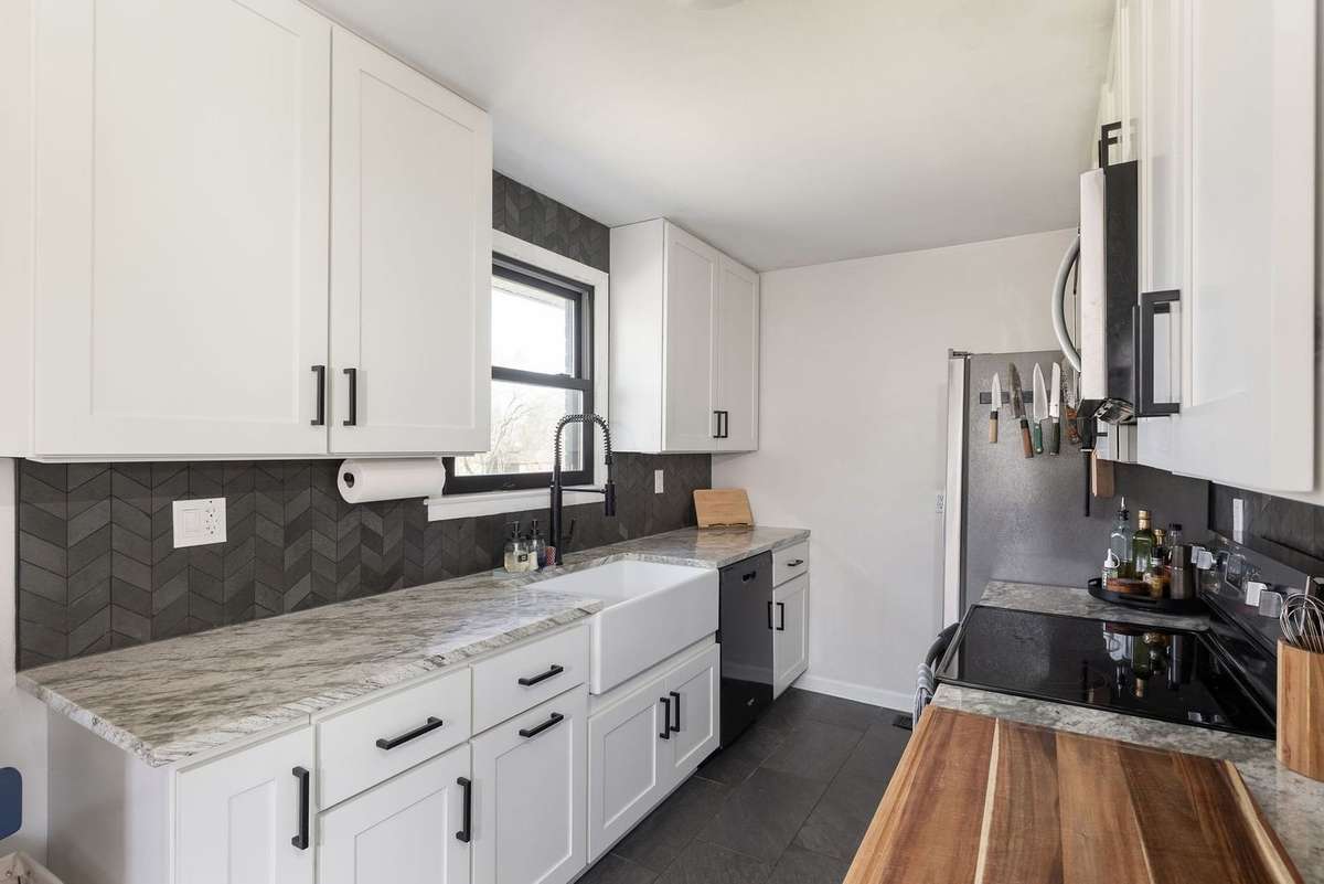 concealed kitchen with tons of prep space and stone countertops