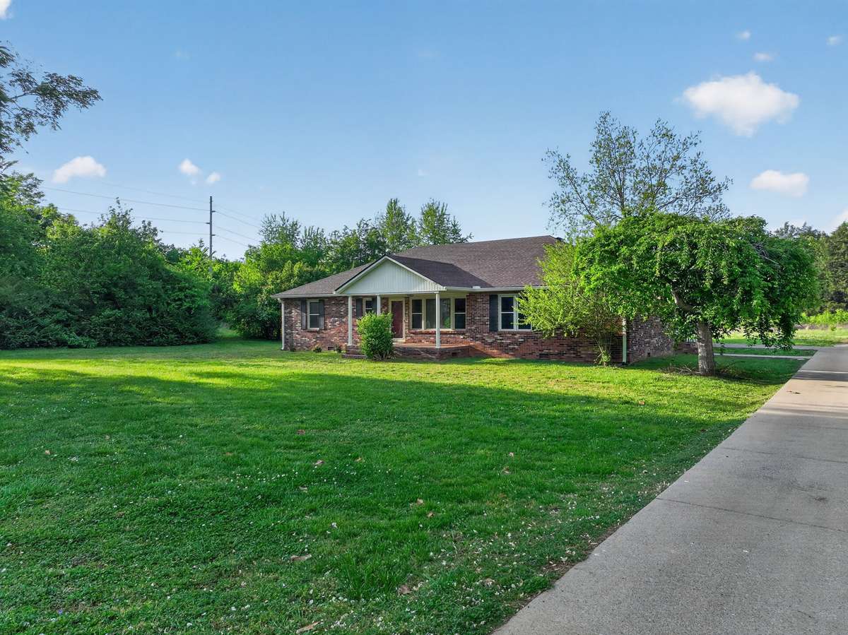 long concrete drive with large yard.