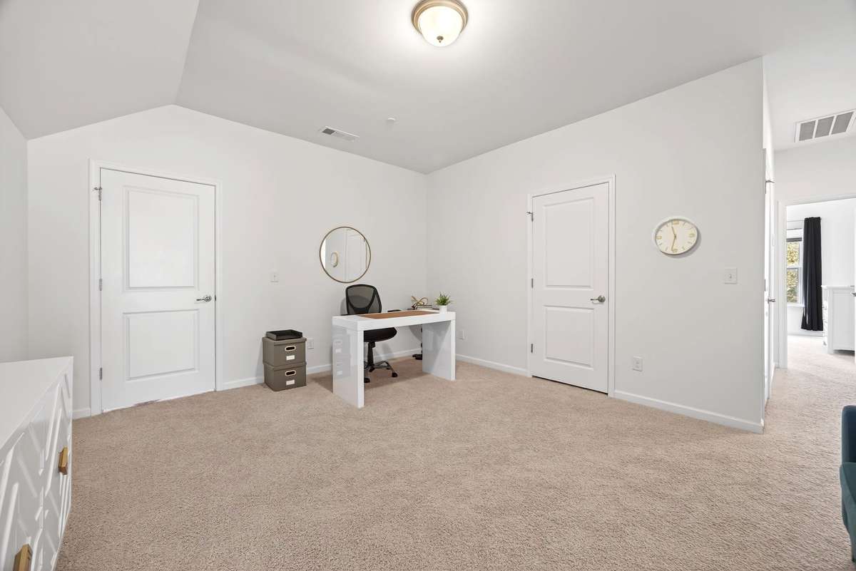 The second level offers versatile living spaces, including this loft area that is currently being utilized as a home office.