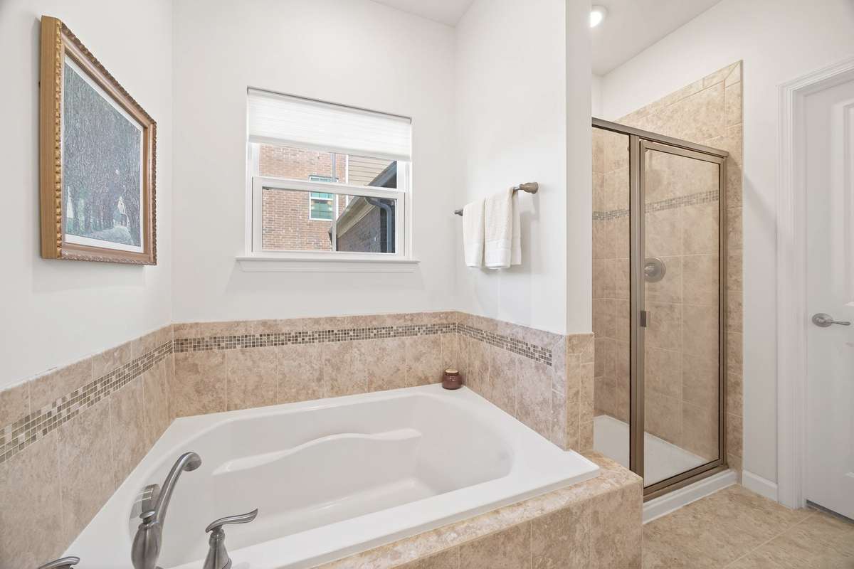 Ahhh! Deep soaking tub with tiled surround and separate walk-in shower with glass door.