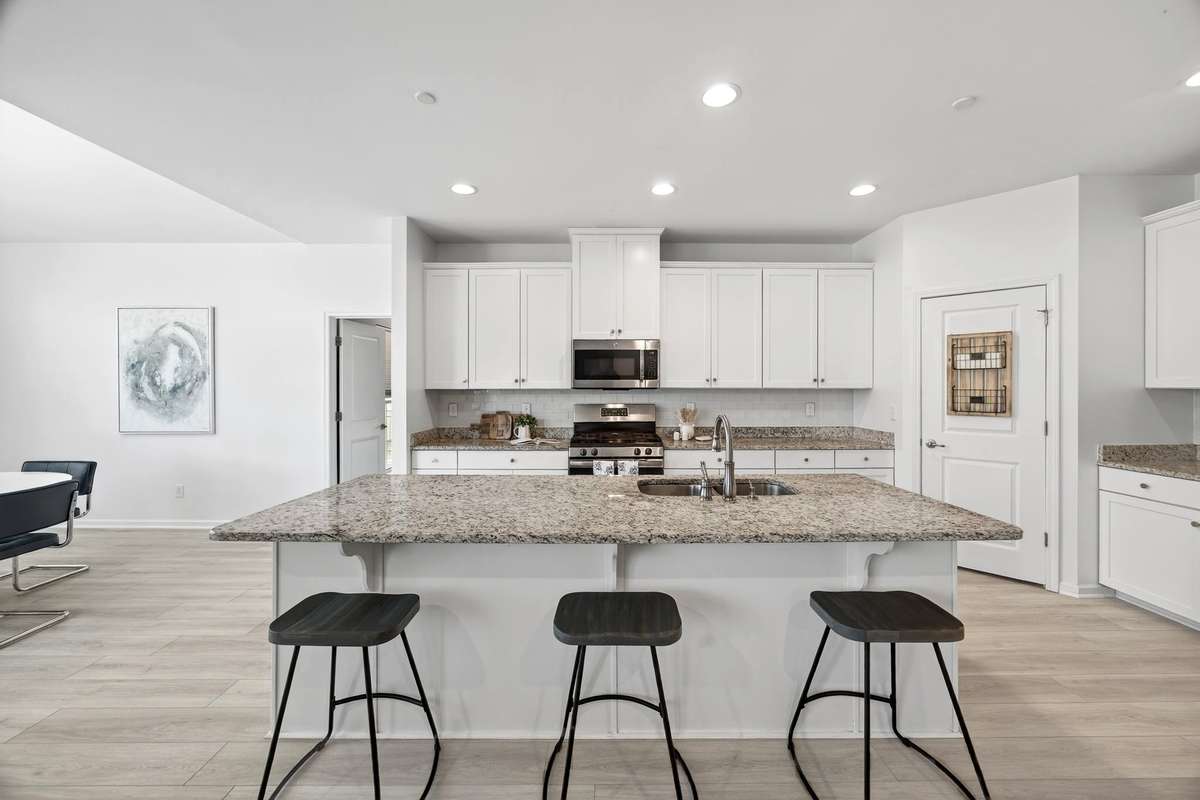 A chef’s dream. The beautiful white cabinetry is perfectly complemented by striking granite counters and provides abundant storage and prep space.