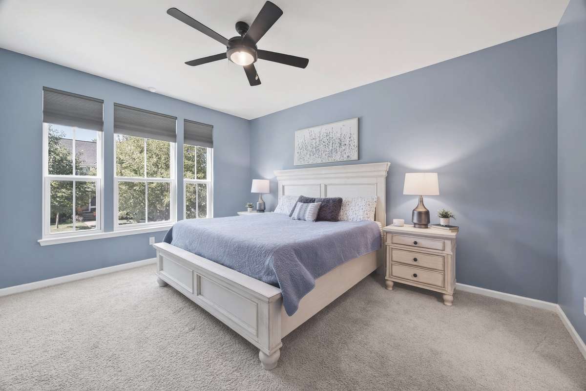 This main-level Primary Suite offers ultimate convenience and comfort, complete with plush carpeting and ceiling fan.