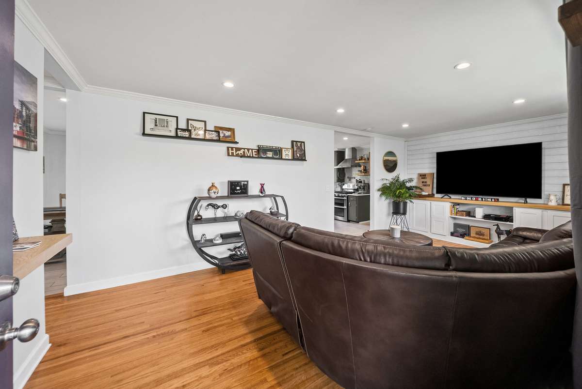 Living room offers built in shelving and large windows offering plenty of natural light.