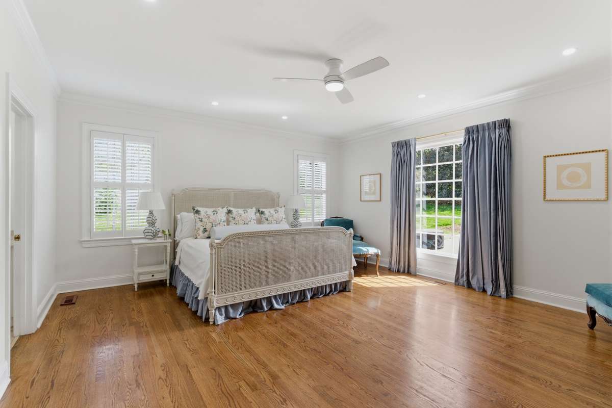 Primary bedroom on the main level overlooking the private backyard.