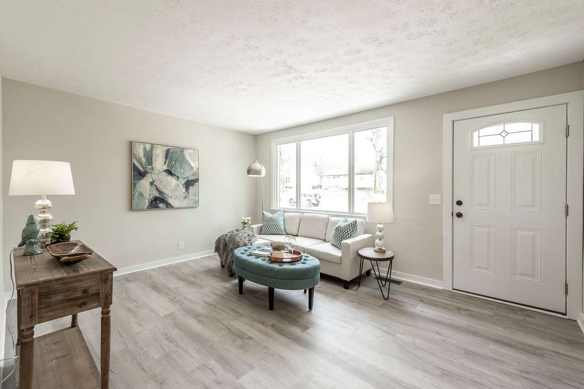 The spacious living room features a large picture window that fills the space with natural light & creates a warm, inviting atmosphere.