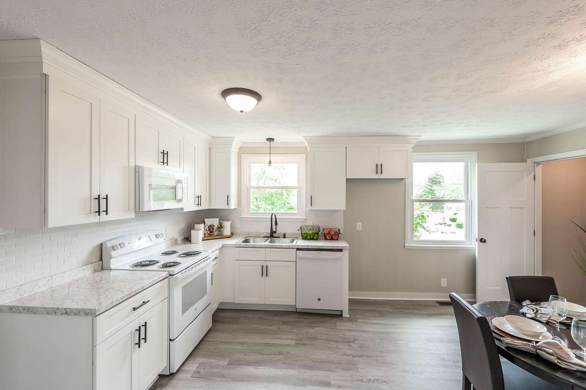 The fully renovated kitchen features crisp white cabinetry that creates a bright, clean, & timeless aesthetic.