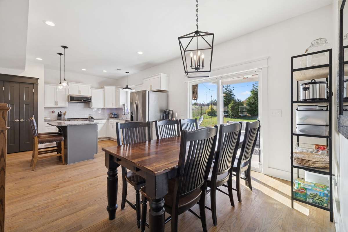 The eat-in kitchen has ample space to serve many on a daily basis, with the flexibility to expand for special holidays. The sliding glass doors open to the expansive yard beyond.