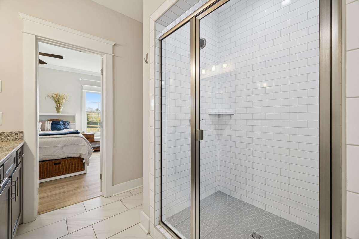 Spacious and inviting, the walk-in shower is finished with crisp white subway tile on the walls and accented with grey floor tiles.  The upgraded glass door adds a touch of sophistication you'll really appreciate.