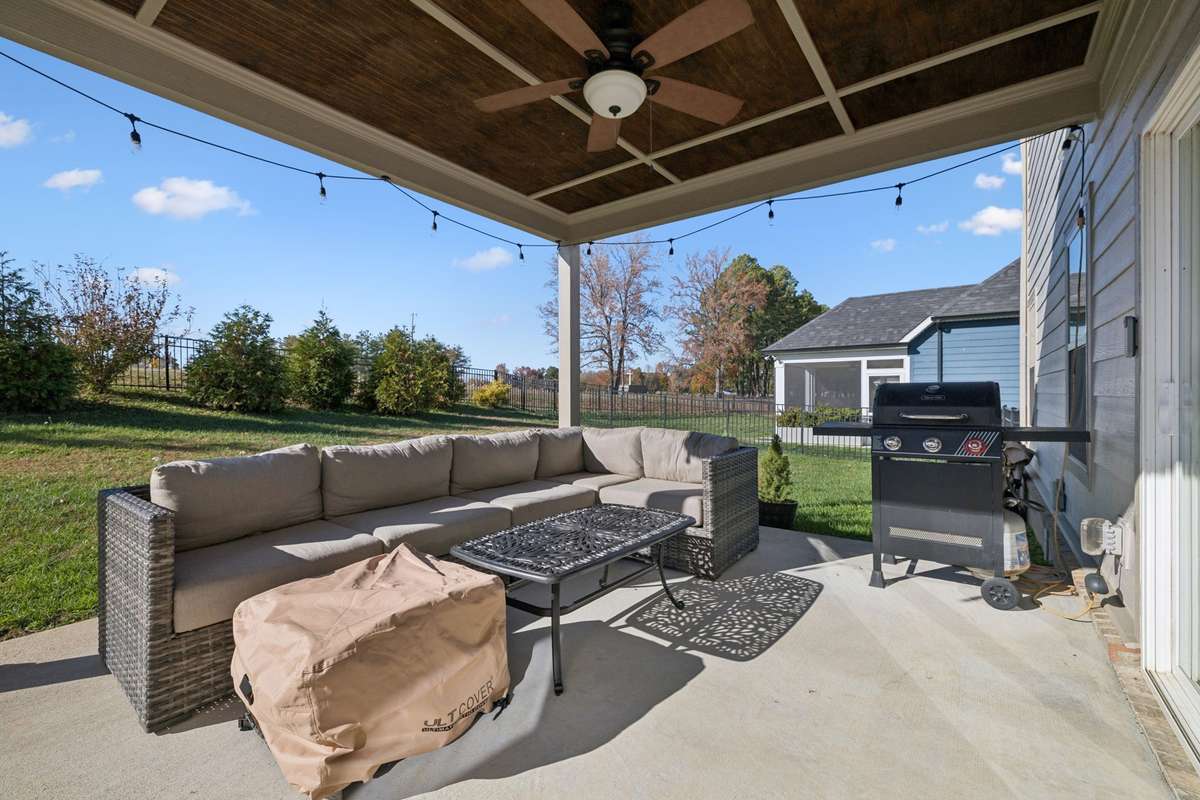 If you aren't in love with this home already, the backyard area is going to grab your heart, starting with this covered patio area off the eat-in area of the kitchen, complete with a decorative beadboard ceiling and a fan.