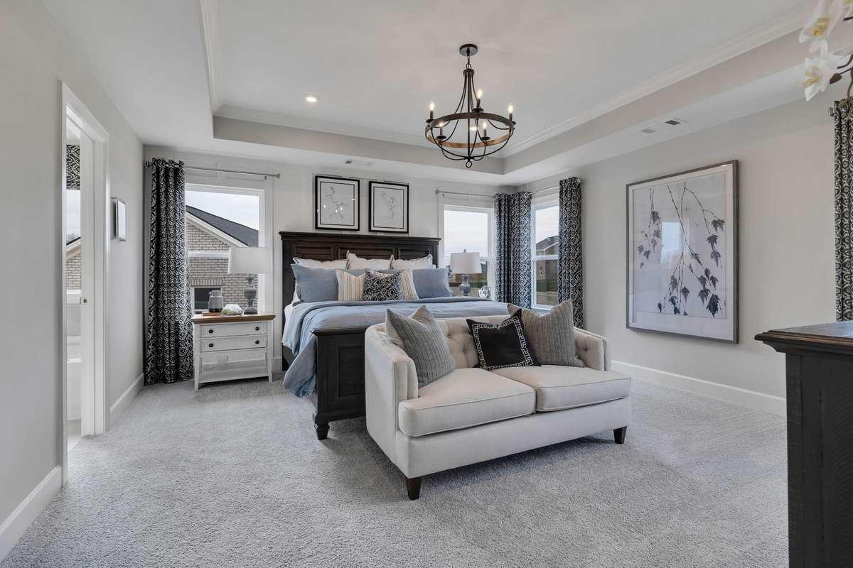 Stock Model Photo. Beautiful Primary Bedroom with included tray ceiling and lots of natural light!