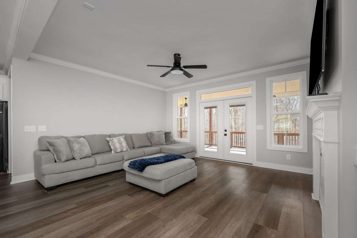 Fireplace, built-ins, and doors that lead you right out to the covered deck and trees beyond.