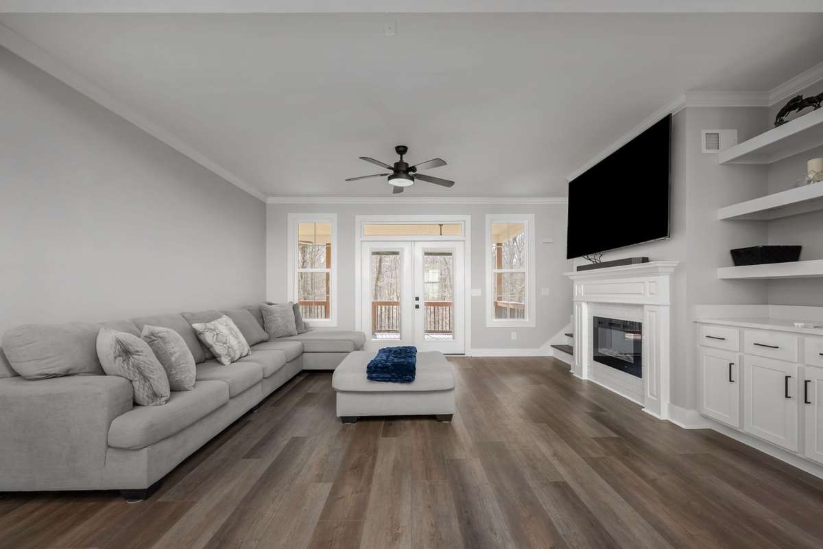 Cozy living room with deck access and peaceful wooded views.
