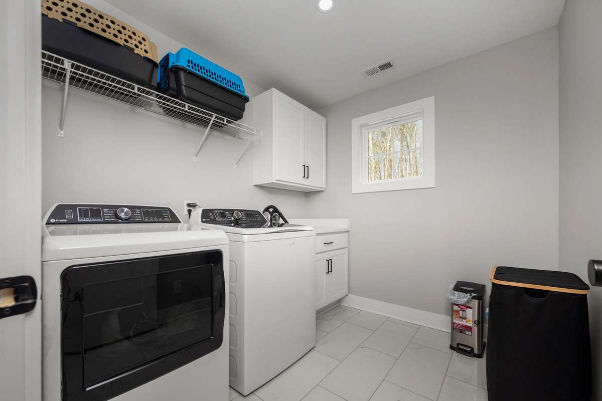 A functional laundry space with tile floors, storage, and a sink that actually comes in handy.