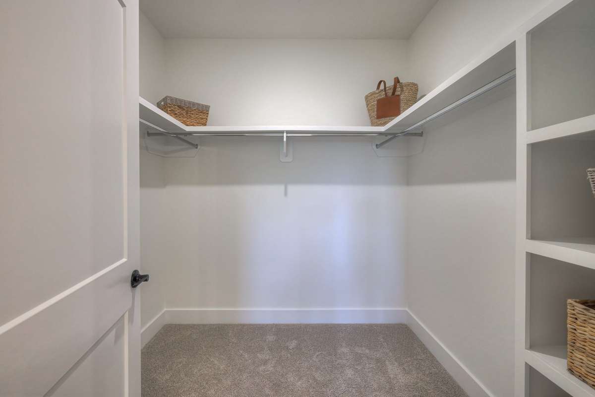 **Photos of the model home owners closet on the main level to show the layout of the floor plan staged with furniture. Not the actual house.**