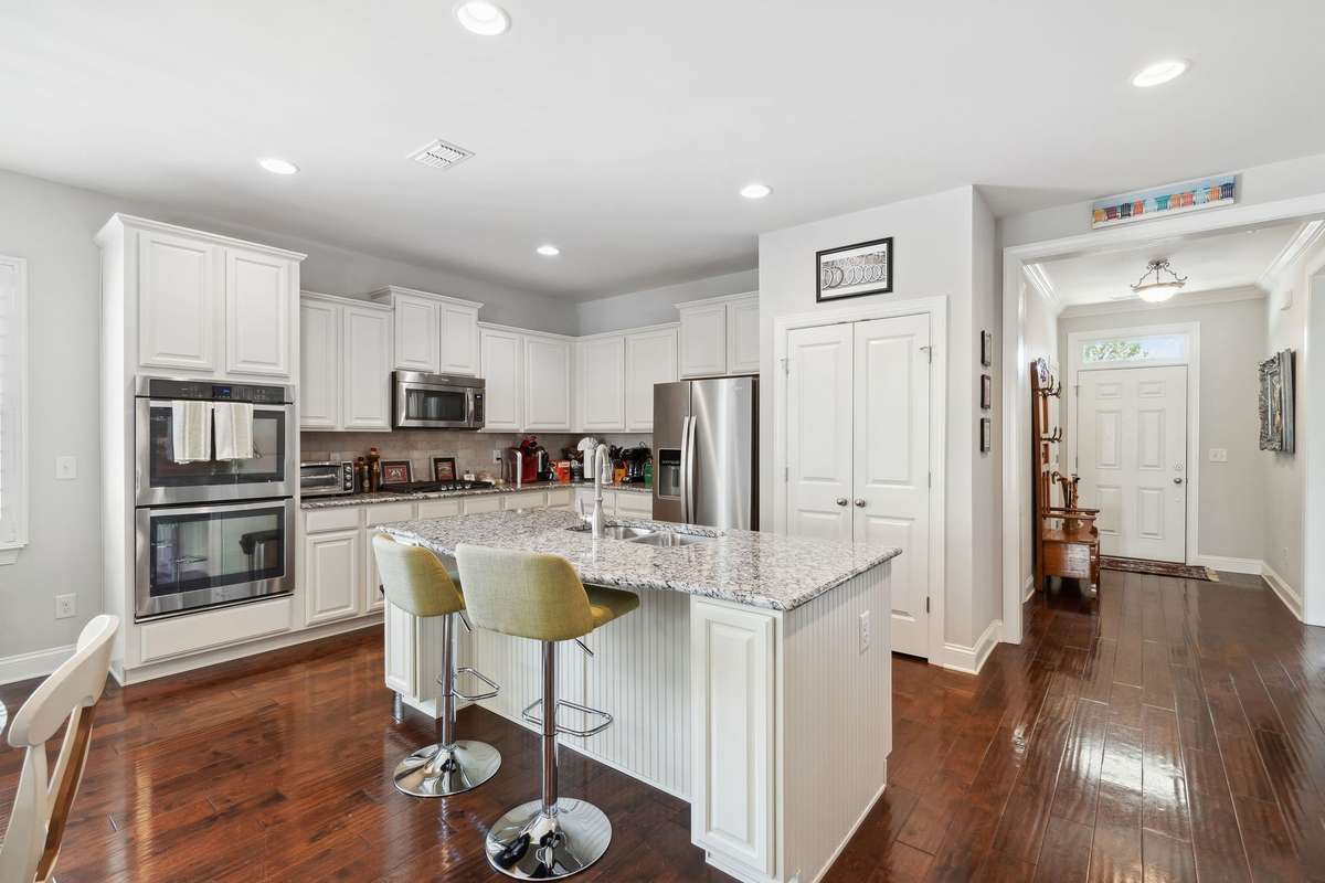 This gourmet kitchen features granite countertops and island with additional seating.