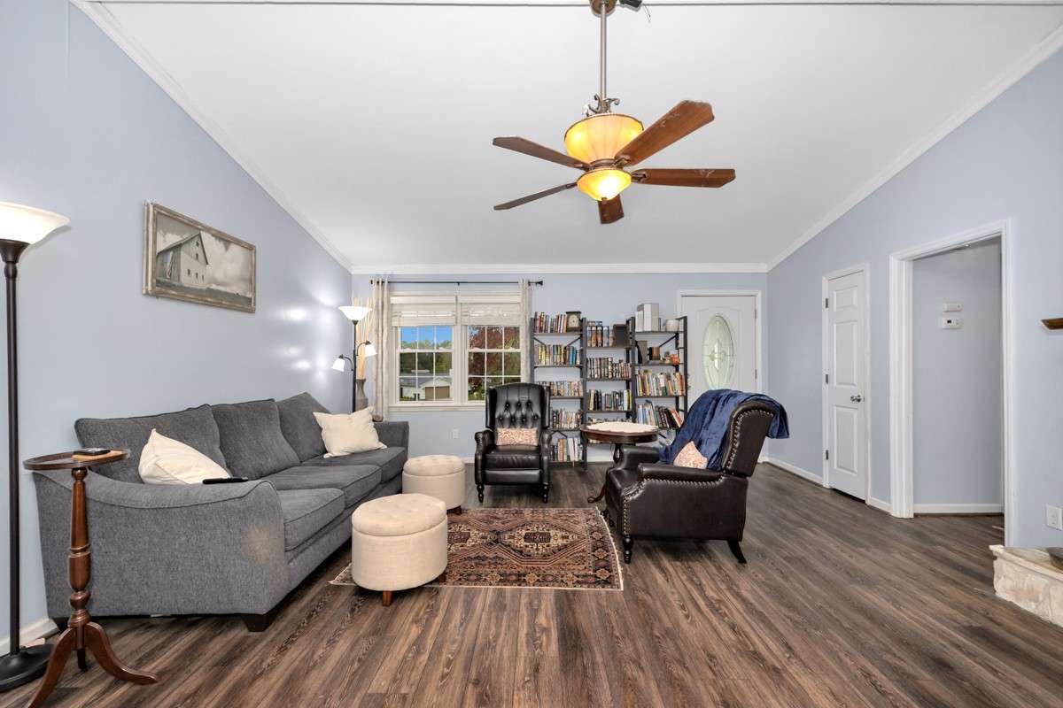 Living Room- LVP flooring, crown molding. vaulted ceiling, ceiling fan, gas log fireplace