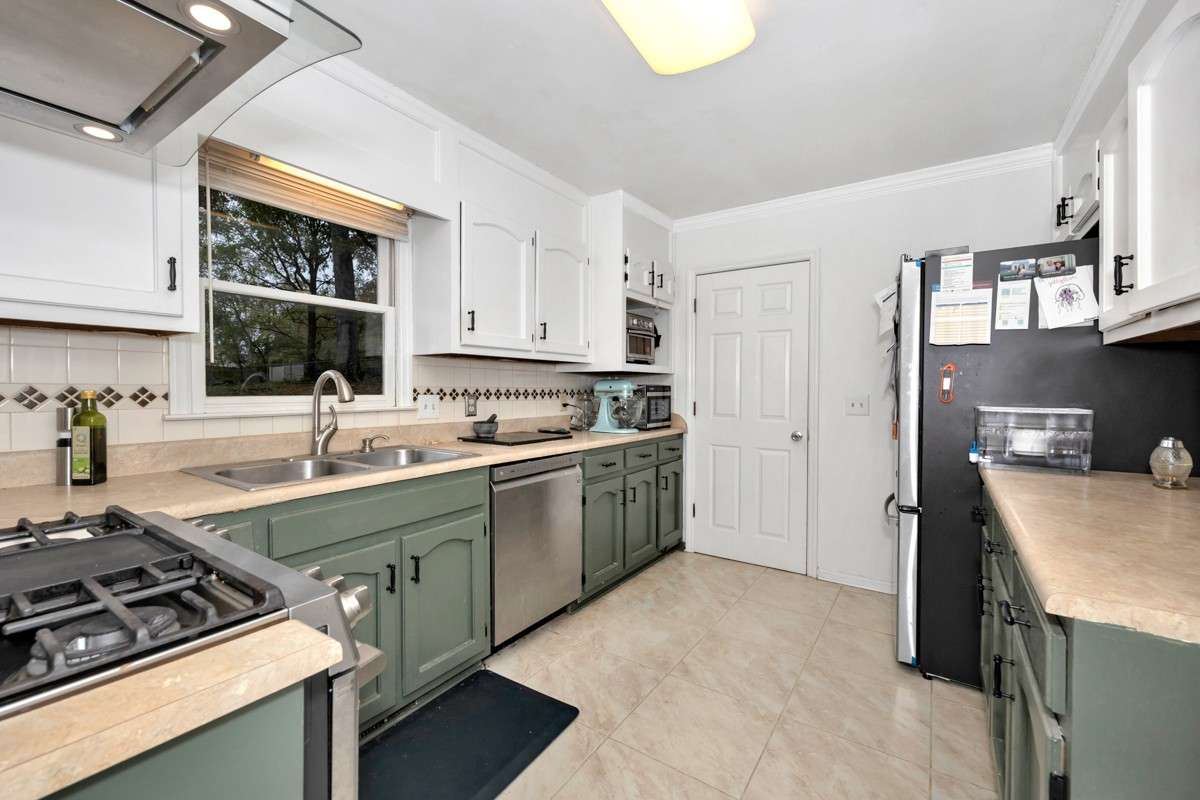 Kitchen- tile flooring & backsplash, stainless steel appliances: dishwasher, double oven, gas stove