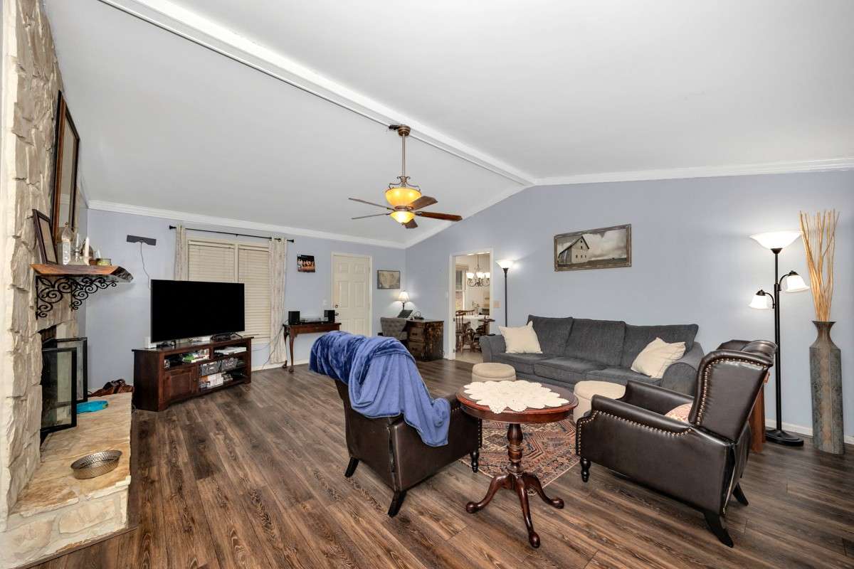 Living Room- LVP flooring, crown molding. vaulted ceiling, ceiling fan, gas log fireplace