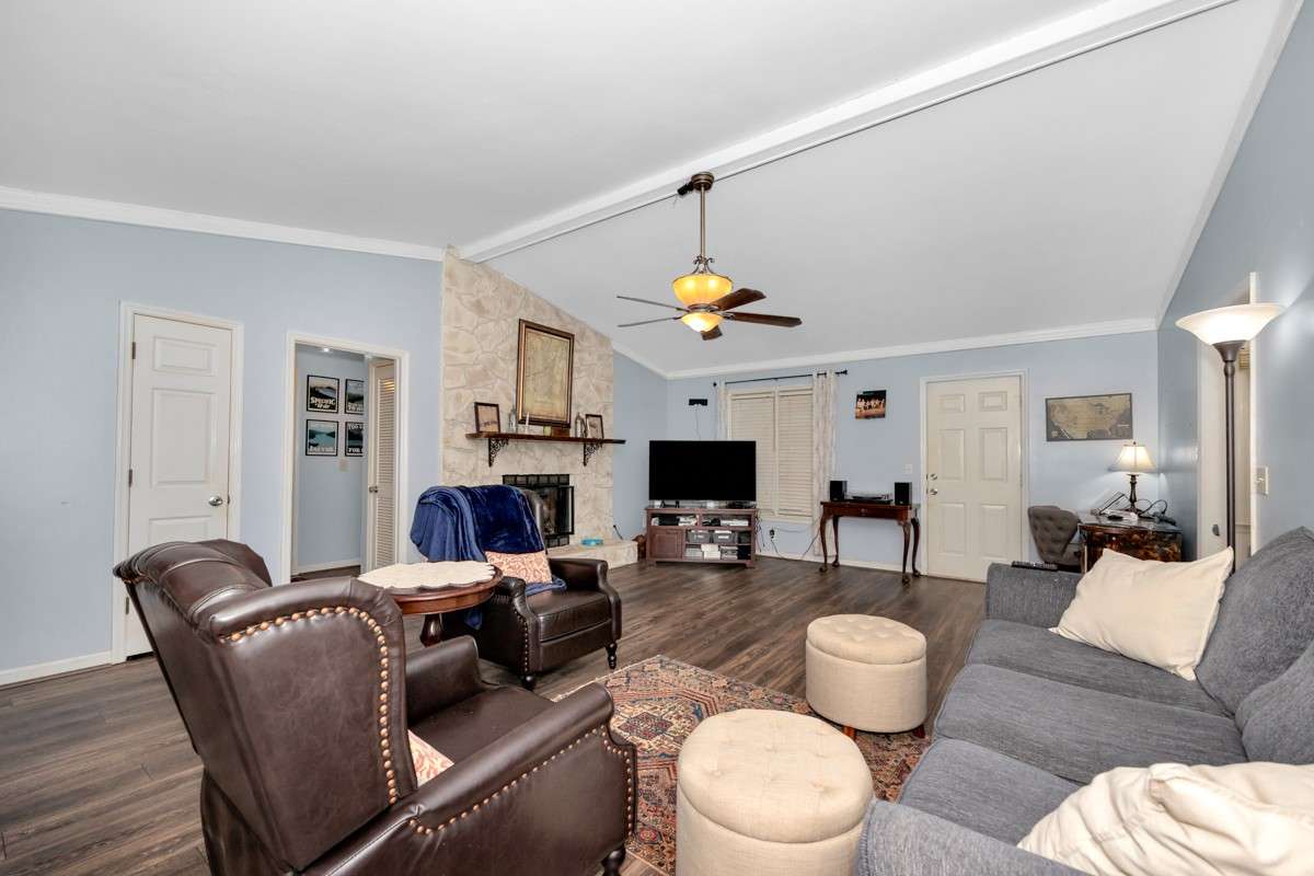 Living Room- LVP flooring, crown molding. vaulted ceiling, ceiling fan, gas log fireplace
