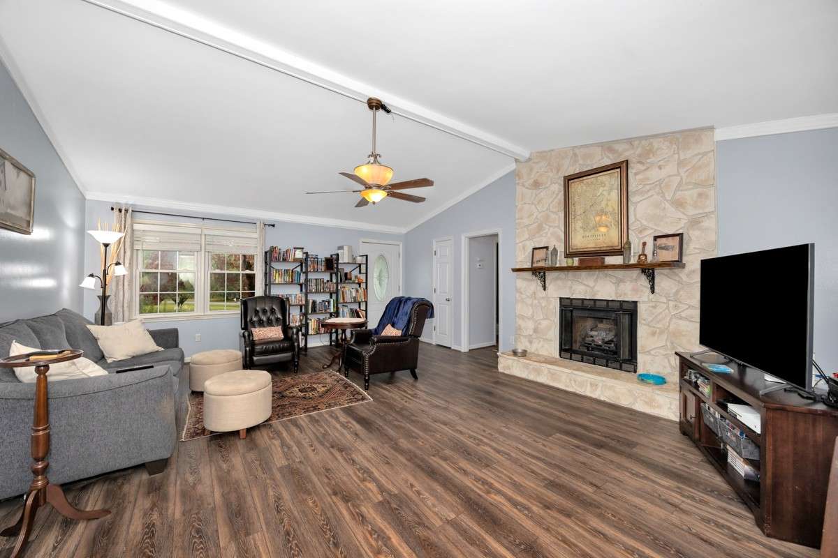 Living Room- LVP flooring, crown molding. vaulted ceiling, ceiling fan, gas log fireplace