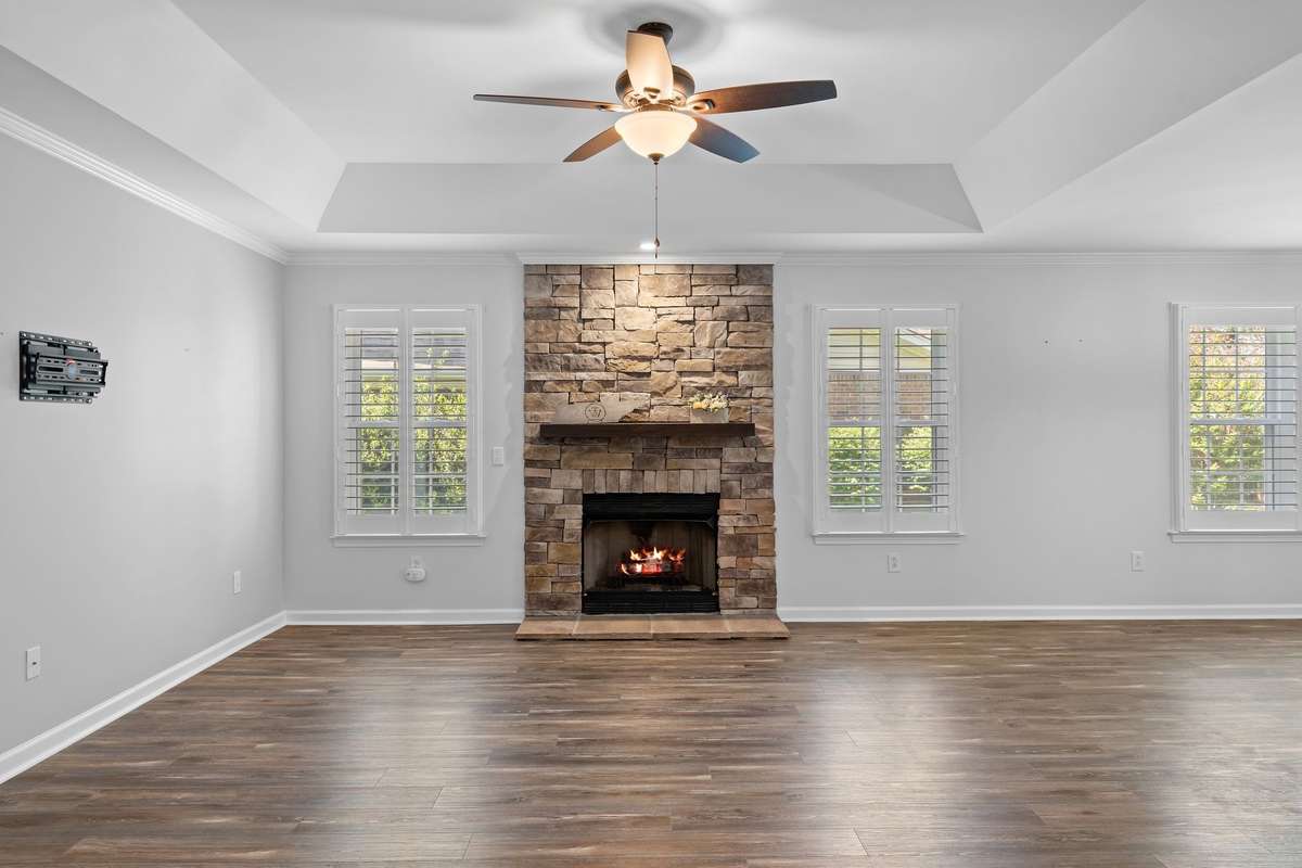 Cozy gas fireplace with a beautiful stone surround and wood mantle!