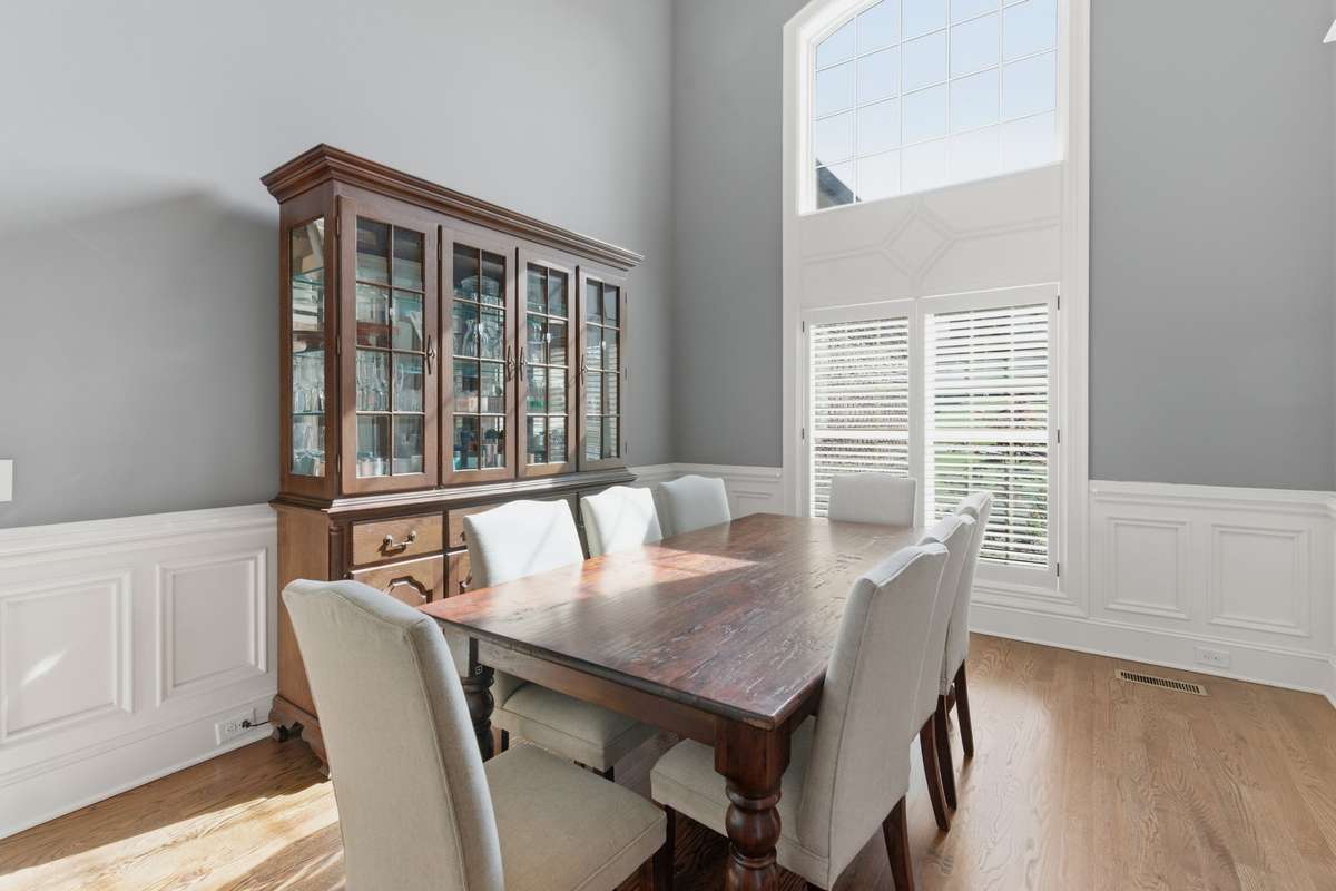This dining room features beautiful trim and a 16' ceiling. The large windows let in lots of natural lighting.