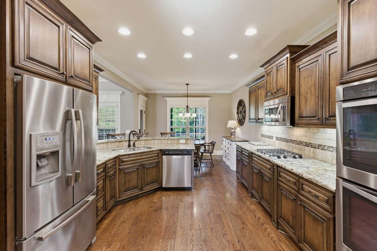 The kitchen has double ovens, a gas cooktop, microwave, and a disposal. The large countertop bar seating is a great spot to enjoy friends and family.